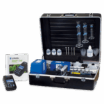 A black carrying case open to reveal a soil testing kit, including bottles, test tubes, measurement tools, and a digital meter. The instruction manual reads “SMART® 3 Electronic Soil Lab Model SCL-15 - 1988-03” by LaMotte.