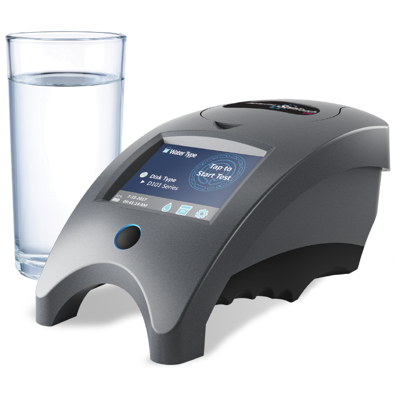 A sleek, modern WaterLink Spin Touch DW - 3585 water testing device with a touchscreen display sits next to a clear glass of water on a white surface. The device shows testing options on its screen.