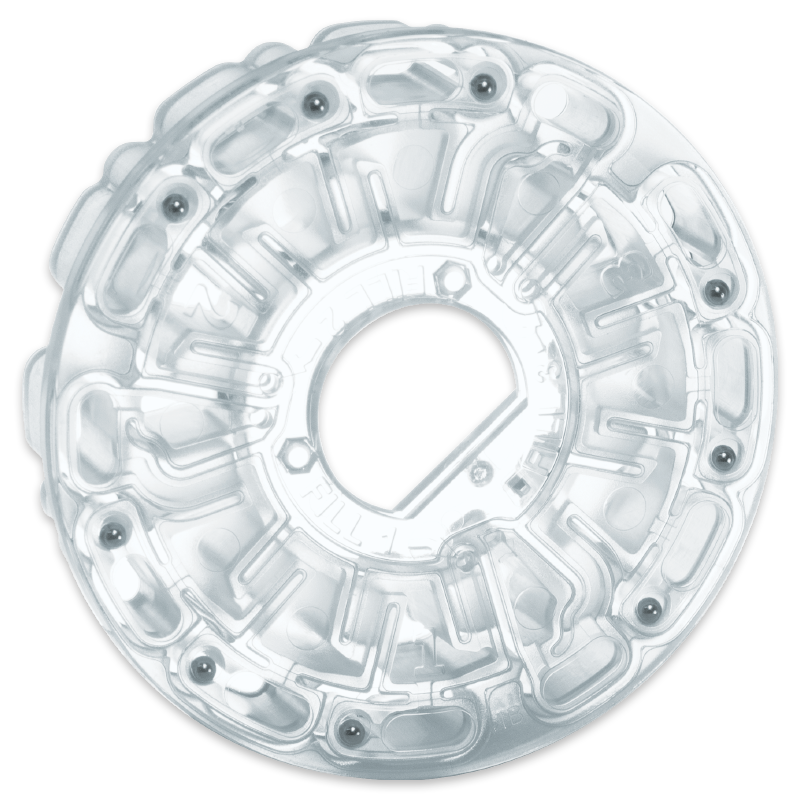 Une cartouche de réactif SpinDisk transparente et circulaire - labyrinthe 4340-H avec de petites billes métalliques à l’intérieur. Le labyrinthe présente un trou central, des chemins sinueux et des bords surélevés avec des marques visibles dans toute la structure.