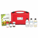 A red carrying case, soil handbook, six bottles of solutions, and the Plant Tissue Macronutrient Test - 5026-01 are arranged on a white background, forming a comprehensive soil test kit.