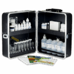 A black carrying case open to reveal various bottles, test tubes, droppers, and scientific supplies, along with brochures or instruction booklets laid out in front. The Model STH-7 - Soil Testing Outfit appears organized for laboratory or field testing use.