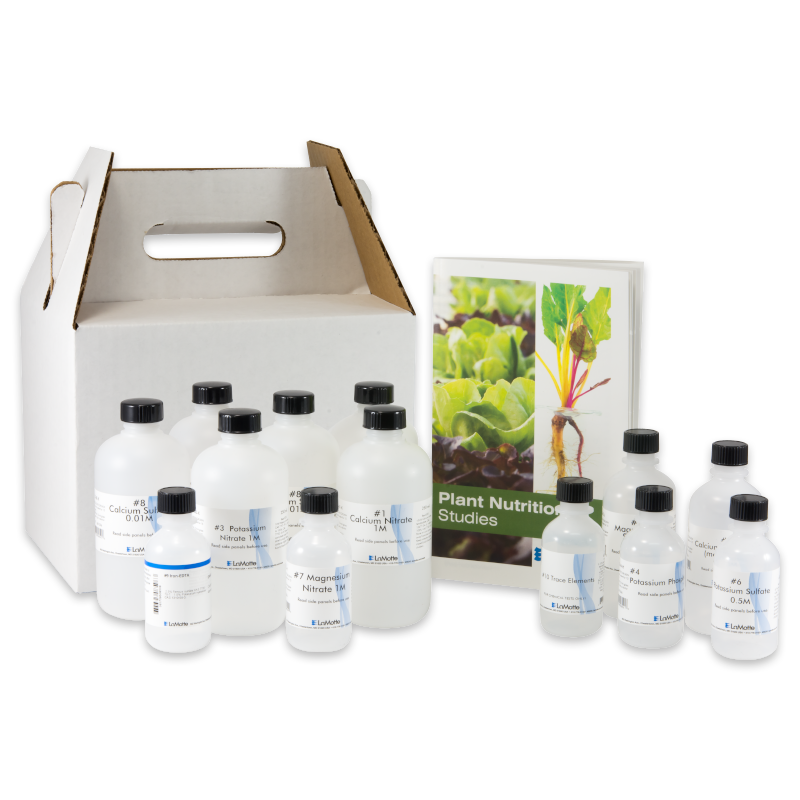Un conjunto de botellas de plástico con etiquetas científicas está colocado junto a un folleto titulado Estudios de Nutrición Vegetal - 5940. Detrás de los objetos se coloca una funda blanca de cartón con asa para el portador.