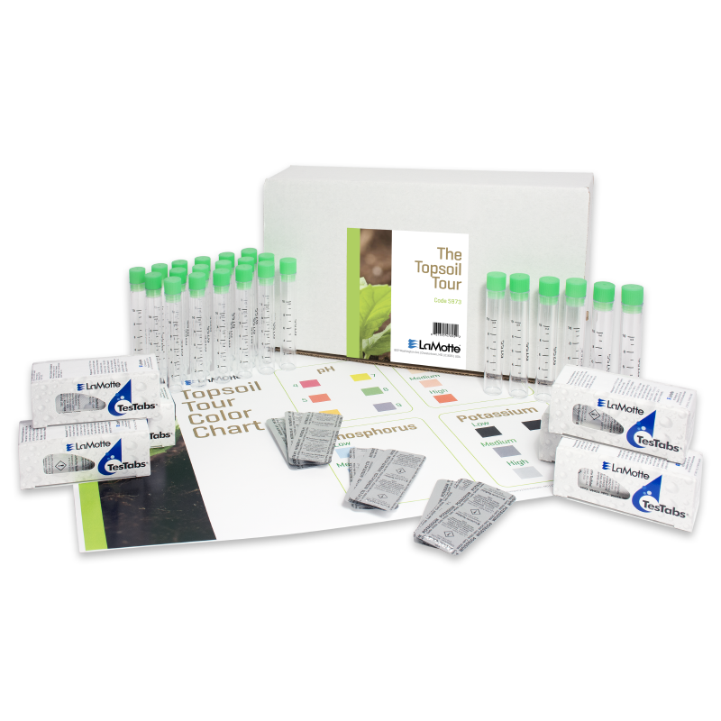 Un kit de análisis de suelo, Topsoil Tour - 5973-01, incluye tubos de ensayo con tapas verdes, tabletas de reactivos, hojas de instrucciones, una tabla de colores y una caja blanca etiquetada The Topsoil Tour by LaMotte, todo dispuesto sobre una superficie blanca.