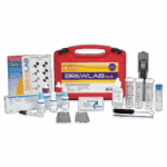 A red carrying case labeled BrewLab® Plus 7188-02 is surrounded by water testing supplies, including bottles, test tubes, a brush, a digital meter, color comparison cards, and instruction manuals.