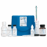 The Caustic Test Kit - 7516-DR-02 features a blue plastic case, labeled bottles of deionized water, hydrochloric acid, barium chloride, plus a syringe, dropper, measuring tube, and scoop neatly arranged in front.